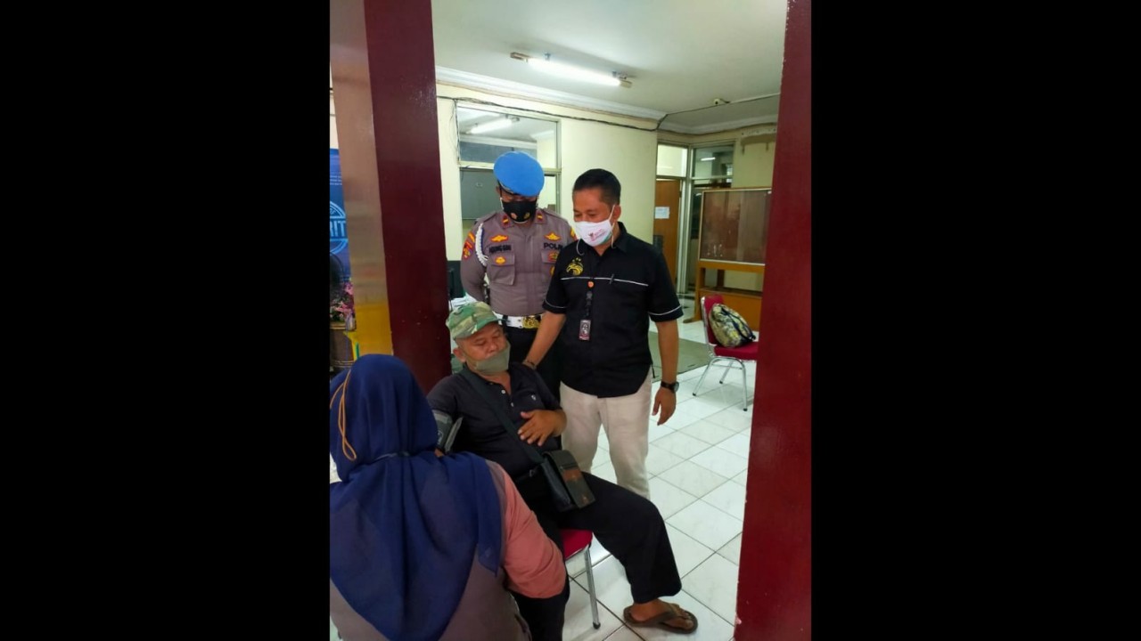 Penjual siomay didampingi Iptu Ubaidilah Ishaq saat hendak divaksinasi.