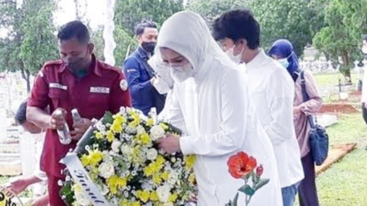 Arzeti Bilbina tabur bunga di pusara ayah mertuanya. (net)