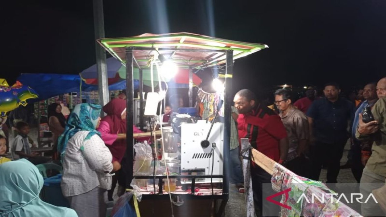 Bupati Manokwari, Hermus Indou, saat berbelanja es tebu di salah satu lapak UMKM masyarakat di Kampung Udapi Hilir, SP 4, Distrik Prafi, Jumat (28/10/2022) malam. (ANTARA/Rachmat Julaini)
