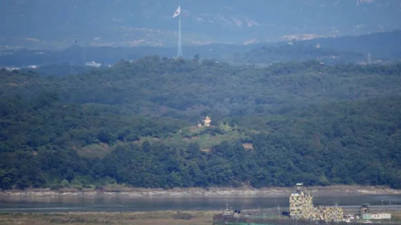 Pos penjagaan Korea Selatan dan Korea Utara saling berhadapan saat bendera nasional Korea Selatan berkibar dalam gambar yang diambil dari Unification Observation Platform, dekat zona demiliterisasi yang memisahkan kedua Korea di Paju, Korea Selatan, 6 Oktober 2022. (Reuters)