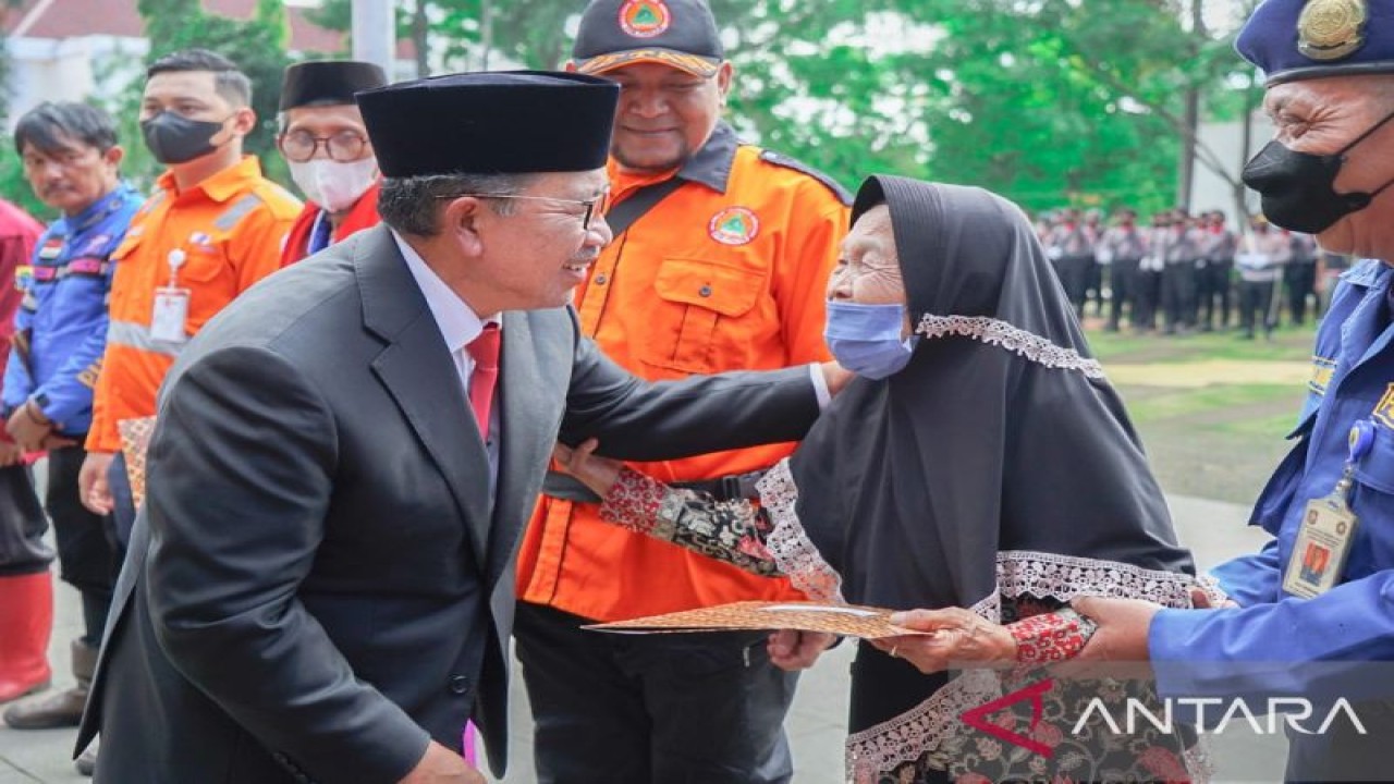 Ma Acum (80), dukun beranak yang warga Kecamatan Cugenang, Cianjur, Jawa Barat menerima penghargaan sebagai pahlawan kecil yang diserahkan Bupati Cianjur Herman Suherman bertepatan dengan peringatan Hari Pahlawan di daerah itu, Kamis (10/11/2022). (ANTARA/Ahmad Fikri)