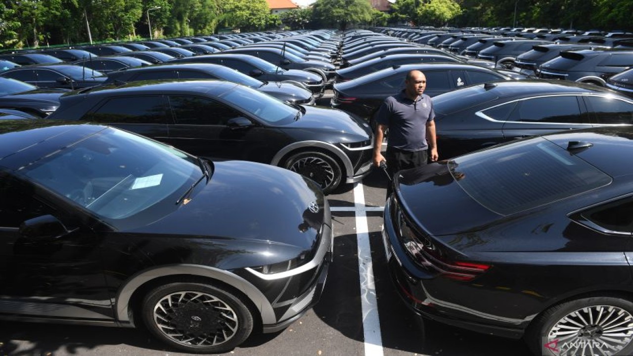 Anggota Paspampres berjaga di samping mobil listrik yang akan digunakan oleh delegasi KTT G20 di Nusa Dua, Bali, Kamis (10-11-2022). Penggunaan mobil listrik sebagai kendaraan resmi dalam perhelatan KTT G20 merupakan bentuk komitmen pemerintah dalam mengurangi emisi karbon. ANTARA/Akbar Nugroho Gumay/wsj