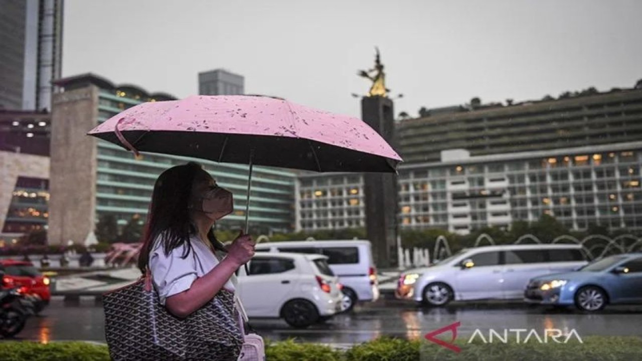Arsip foto - Seorang warga menggunakan payung saat turun hujan di kawasan Bundaran Hotel Indonesia, Jakarta, Selasa (4/10/2022). (ANTARA FOTO/M Risyal Hidayat/tom/pri)
