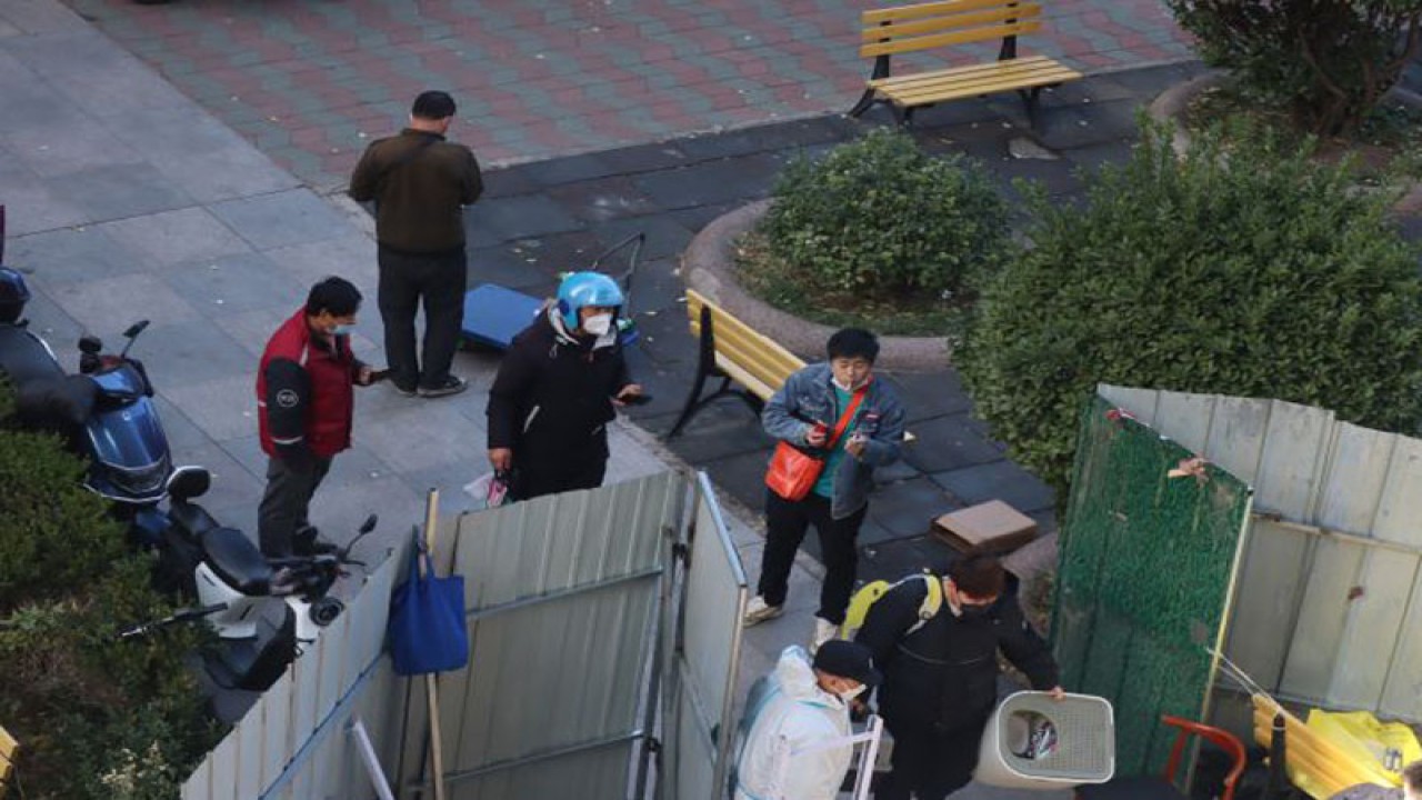 Petugas kesehatan memeriksa setiap orang yang memasuki pintu kompleks apartemen di Distrik Chaoyang, Beijing, China, yang ditutup pagar seng, Senin (21/11/2022), karena sedang diberlakukan karantina wilayah atau lockdown secara parsial. ANTARA/M. Irfan Ilmie