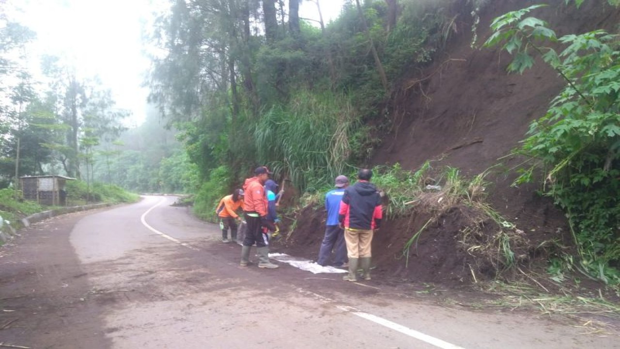 Petugas membersihkan sisa material longsor yang berada di tepi jalan menuju wisata Gunung Bromo di Kecamatan Sukapura, Senin (28/11/2022). (ANTARA/HO-BPBD Probolinggo)
