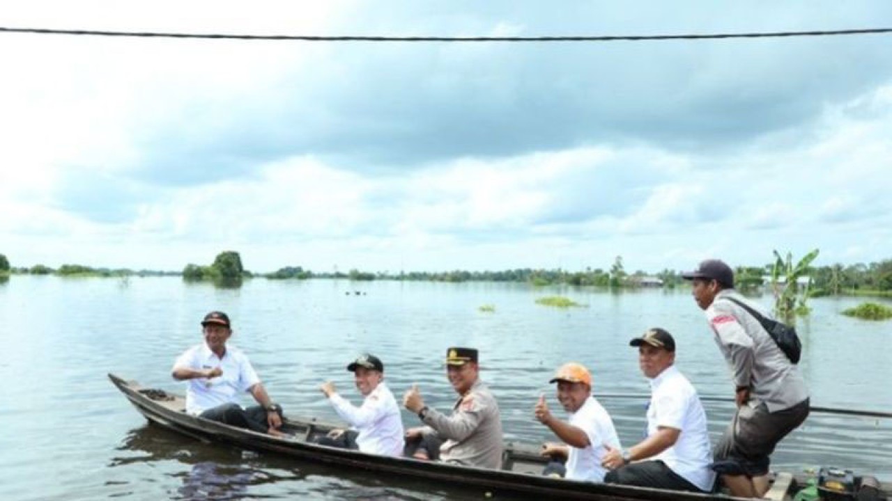 Pj Bupati HSU Raden Suria Fadliansyah bersama Ketua DPRD dan Forkopimda meninjau situasi dan kondisi warga terdampak banjir menggunakan perahu mesin di Desa Danau Terate Kecamatan Banjang, Rabu (23/11/22). (ANTARA/Eddy A/Diskominfo HSU)