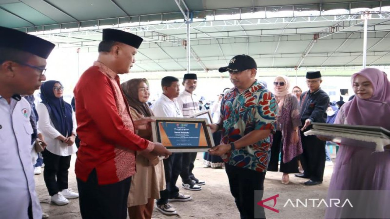 Bupati Hamim Pou (kanan) menyerahkan sertifikat kepada desa yang telah terbebas dari buang air besar sembarangan (BABS) di Bone Bolango, Gorontalo. ANTARA/HO-Diskominfo Bone Bolango