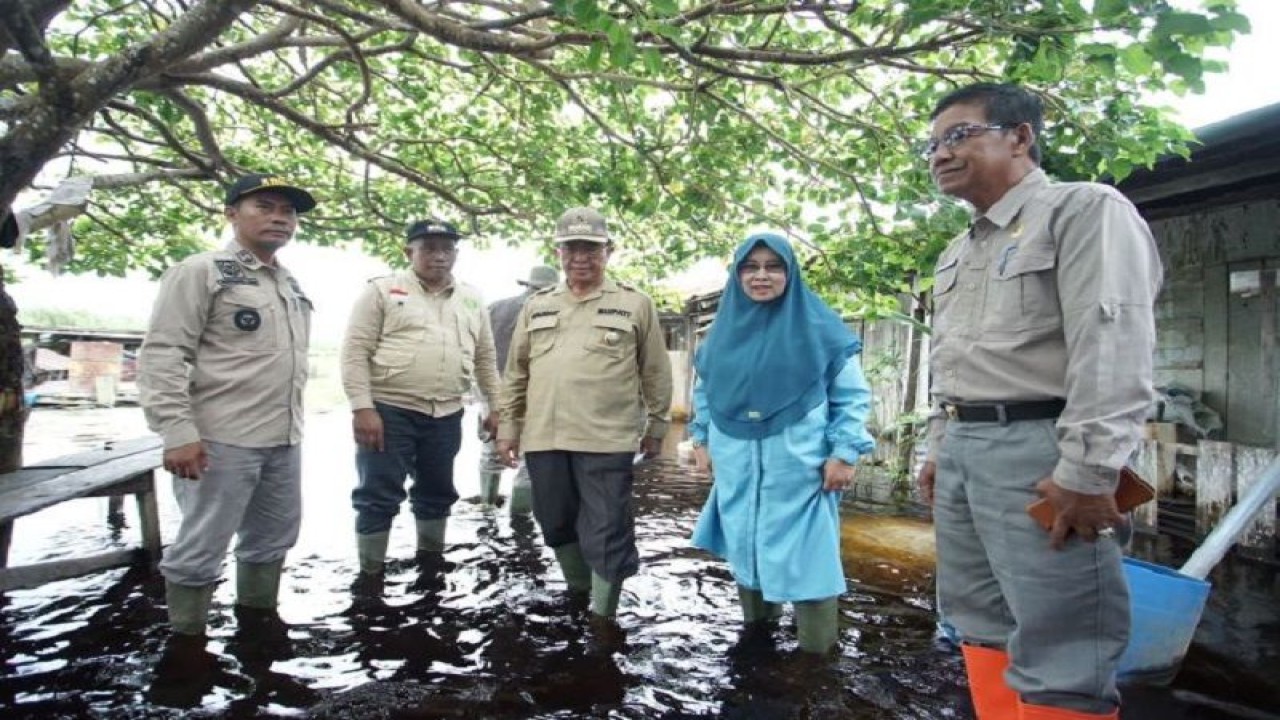 Arsip Foto. Bupati Indragiri Hilir Muhammad Wardan (kanan) bersama ketua Tim Penggerak PKK Kabupaten Indragiri Hilir Zulaikhah Wardan saat meninjau dampak banjir di Desa Kuala Sebatu. (ANTARA/Adriah)