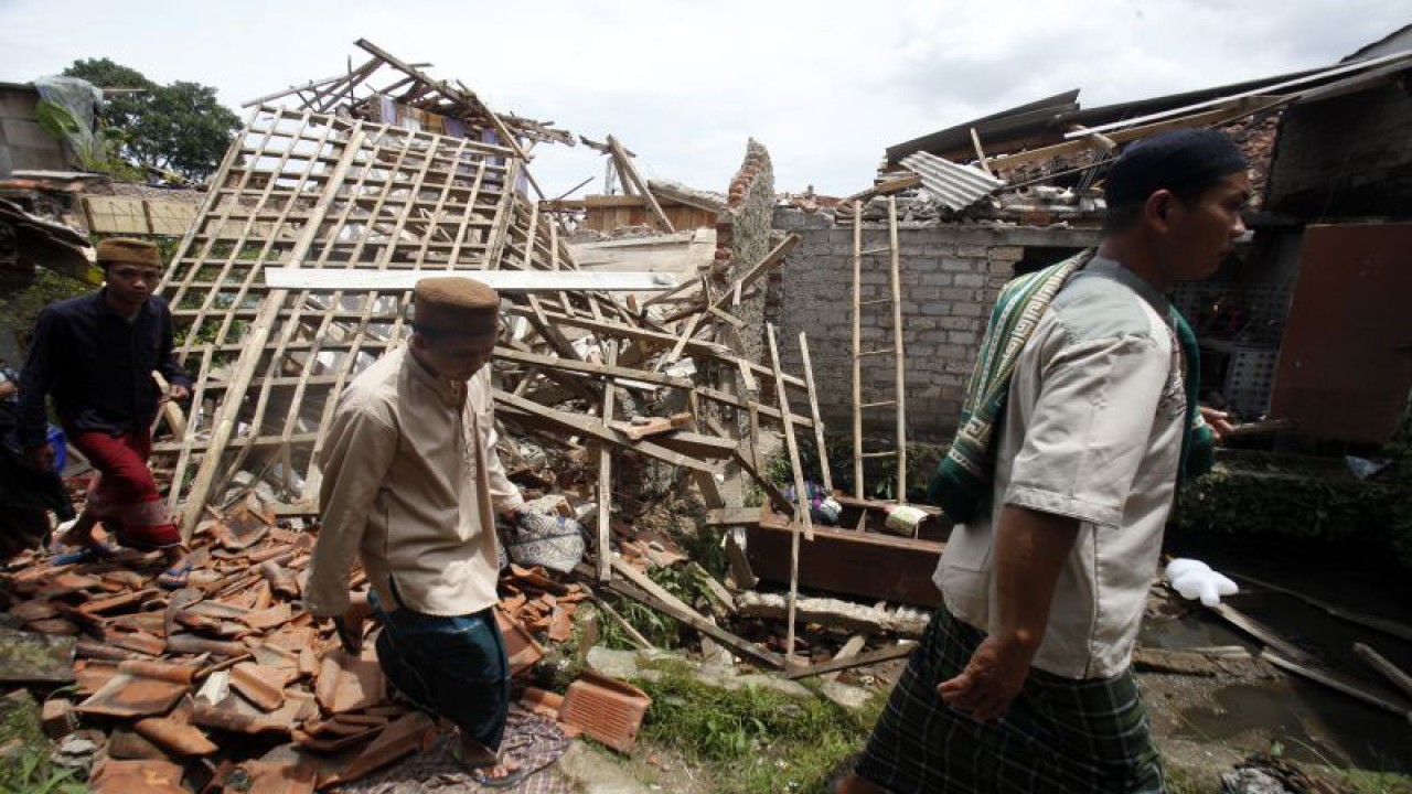 Arsip Foto. Warga melewati rumah yang rusak akibat gempa untuk menuju ke tempat pelaksanaan shalat di Desa Gasol, Kabupaten Cianjur, Provinsi Jawa Barat, Jumat (25/11/2022). (ANTARA FOTO/Yulius Satria Wijaya/aww)