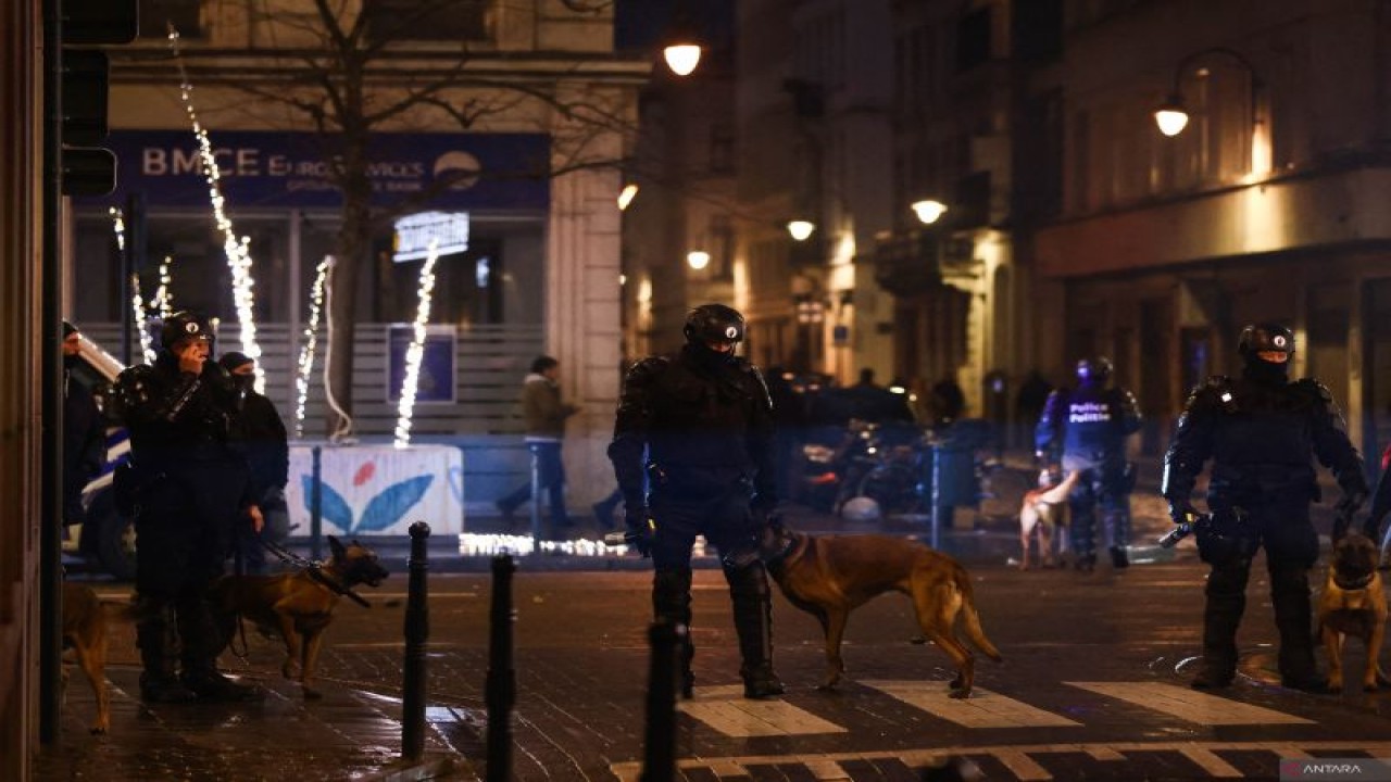 Sejumlah polisi berjaga-jaga di salah satu lokasi "nonton bareng" pertandingan Piala Dunia 2022 Qatar antara Belgia kontra Maroko di Brussel, Minggu (27/11/2022). Sekelompok fans mengamuk dan menyerang polisi setelah Belgia kalah 2-0 dalam pertandingan itu. (AFP/KENZO TRIBOUILLARD)