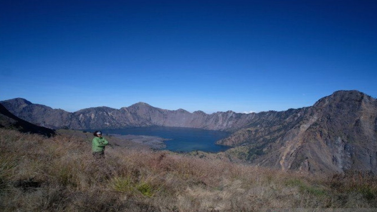 Seorang wisatawan menikmati panorama Danau Segara Anak di atas Gunung Rinjani di Pulau Lombok, Nusa Tenggara Barat (NTB). ANTARA/Riza Fahriza.