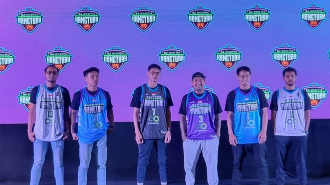 Pemain baru tim IBL RJ Amartha Hangtuah, Daniel Wenas (ketiga kiri) memakai jersey baru saat pengenalan tim di Jakarta, Rabu (30/11/2022). ANTARA/Bayu Kuncahyo