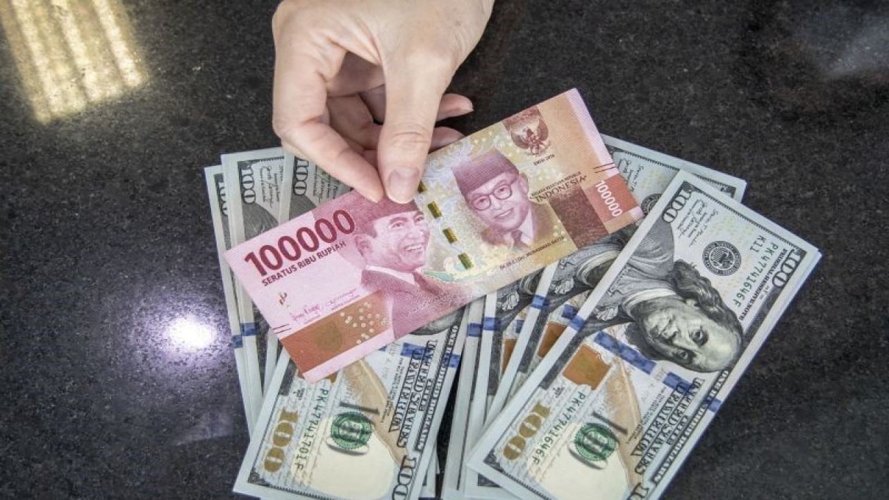 Ilustrasi: Petugas menghitung uang dolar AS dan uang rupiah di salah satu kantor cabang sebuah bank di Jakarta. (ANTARA FOTO/Reno Esnir/foc.)