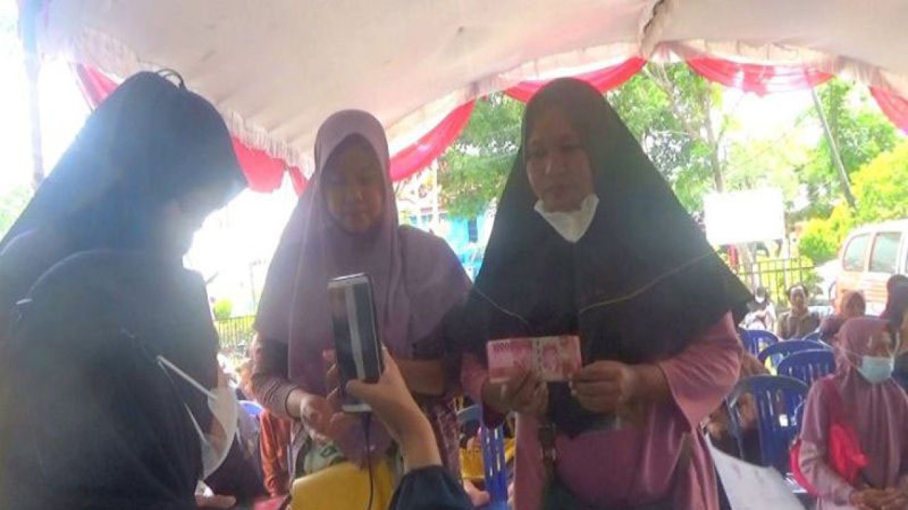 Petugas mendokumentasikan warga Kabupaten Kapuas yang menerima bantuan sosial tunai melalui Kantor Pos Kuala Kapuas, Jumat (25/11/2022). ANTARA/All Ikhwan