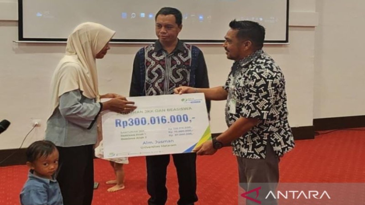 Kepala BPJAMSOSTEK NTB Adventus Edison Suohuwat (kanan) menyerahkan santunan sebesar Rp300 juta kepada ahli waris peserta program Jaminan Sosial Ketenagakerjaan, di Mataram, Kamis (10/11/2022). ANTARA/Awaludin
