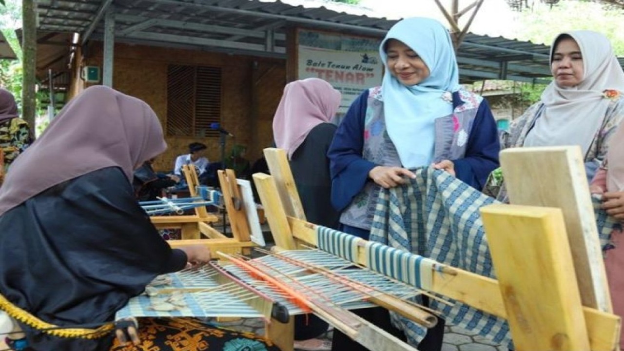 Ketua Dekranasda Nusa Tenggara Barat (NTB), Hj Niken Saptarini Zulkieflimansyah (ketiga kiri) menyaksikan penenun saat mengunjungi Bale Tenun Alam Tenar Desa Batujai dan Sukarare, Lombok Tengah. (ANTARA/Pemprov NTB).