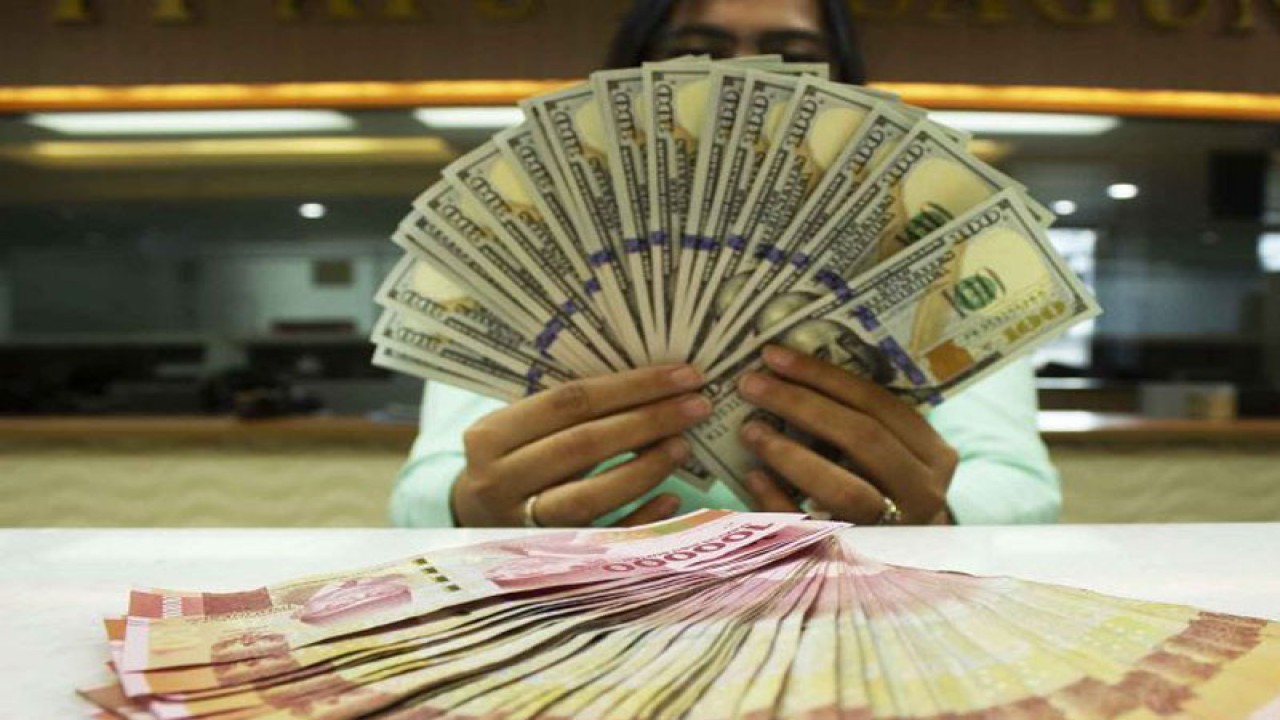 Teller memegang mata uang Dolar AS dan Rupiah di sebuah tempat penukaran uang, Jakarta, Rabu (6/7/2022). Kurs Rupiah ditutup Rp14.999 per Dolar AS pada perdagangan Rabu (6/7) hari ini, melemah 0,03 persen ketimbang posisi penutupan perdagangan kemarin (5/7) pada Rp 14.994 per dolar AS. ANTARA FOTO/Subur Atmamihardja/wsj/foc.