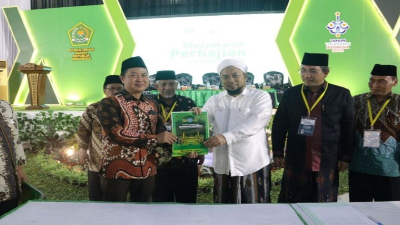 Direktur Jenderal Penyelenggaraan Haji dan Umrah Kementerian Agama Hilman Latief (kiri) menerima rekomendasi penyesuaian Biaya Perjalanan Ibadah Haji (Bipih) dalam forum Mudzakarah Perhajian Indonesia 2022. (ANTARA/HO-Kemenag)