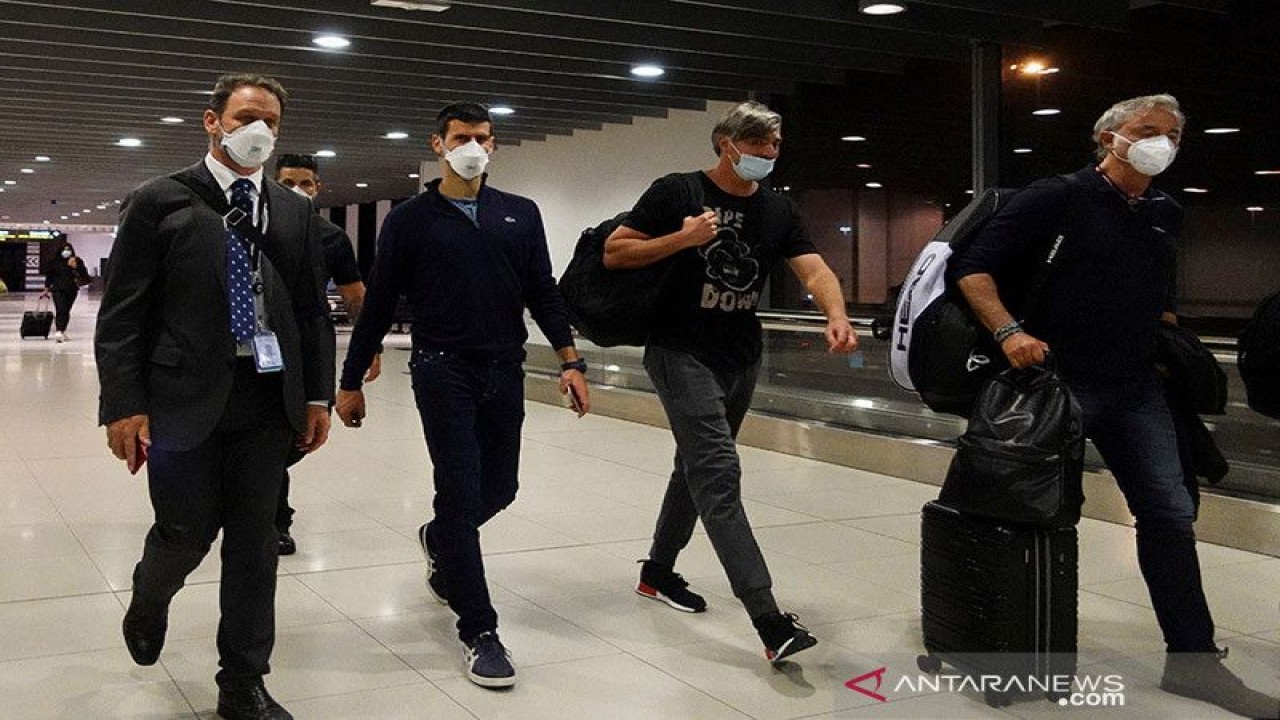 Petenis Serbia Novak Djokovic berjalan di Bandara Melbourne sebelum naik pesawat, setelah Pengadilan Federal menguatkan keputusan pemerintah membatalkan visanya untuk bermain di Australian Open, di Melbourne, Australia, Minggu (16/1/2022). ANTARA/REUTERS/Loren Elliott/am.