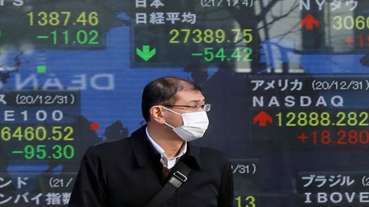Ilustrasi: Seorang pria mengenakan masker wajah pelindung COVID-19 berdiri di depan papan listrik yang menunjukkan Nikkei (atas di C) dan indeks saham negara lain di luar broker di distrik bisnis di Tokyo, Jepang . ANTARA/REUTERS/Kim Kyung-Hoon/aa.
