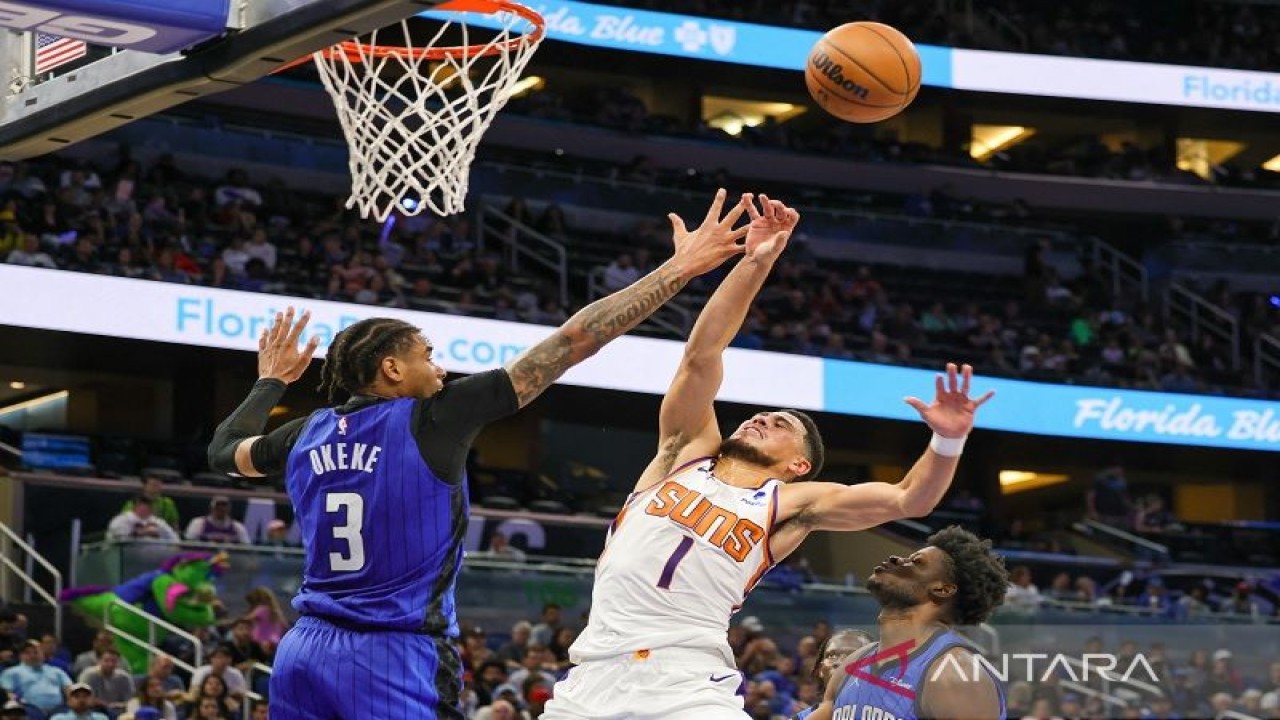 Pebasket Orlando Magic Chuma Okeke (kiri) menghalau tembakan bintang Phoenix Suns Devin Booker dalam lanjutan NBA di Amway Center, Florida, Amerika Serikat, Jumat (11/11/2022) waktu setempat. (ANTARA/REUTERS/SIPA USA/Mike Watters)