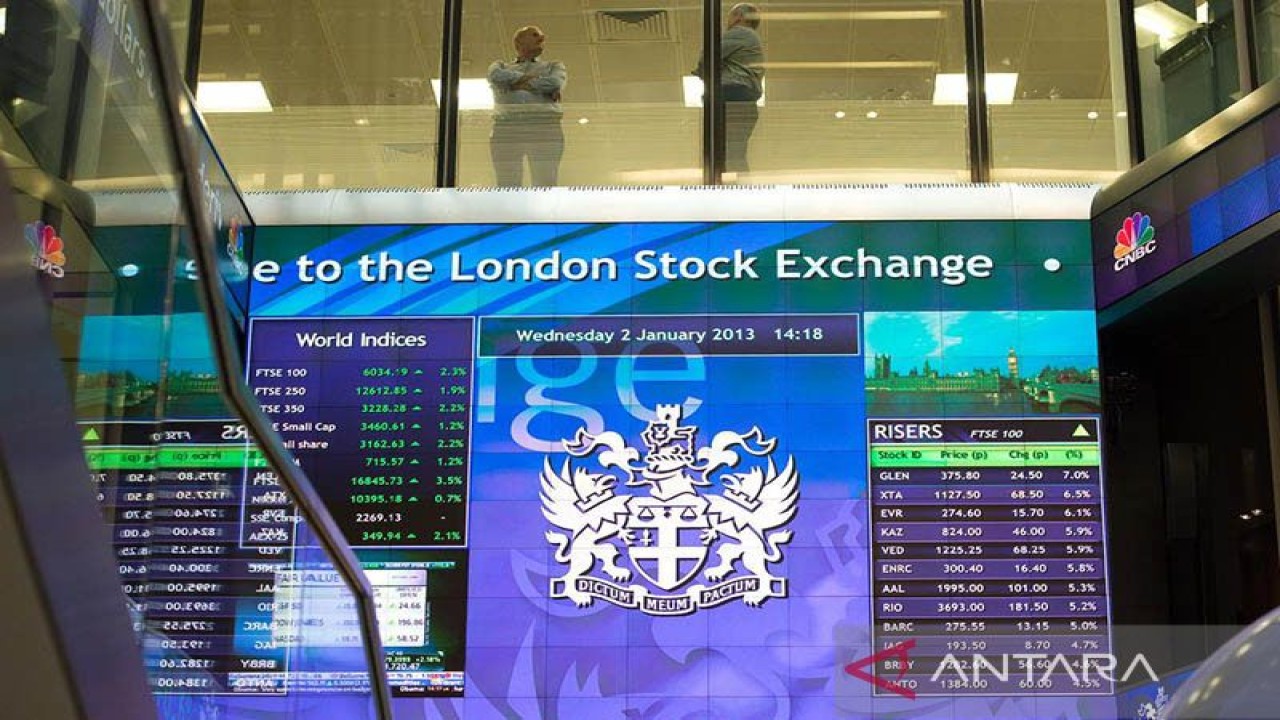 Pekerja terlihat berbincang di atas papan elektronik pergerakan saham di London Stock Exchange, Inggris. REUTERS/Paul Hackett/aa. (REUTERS/Paul Hackett)