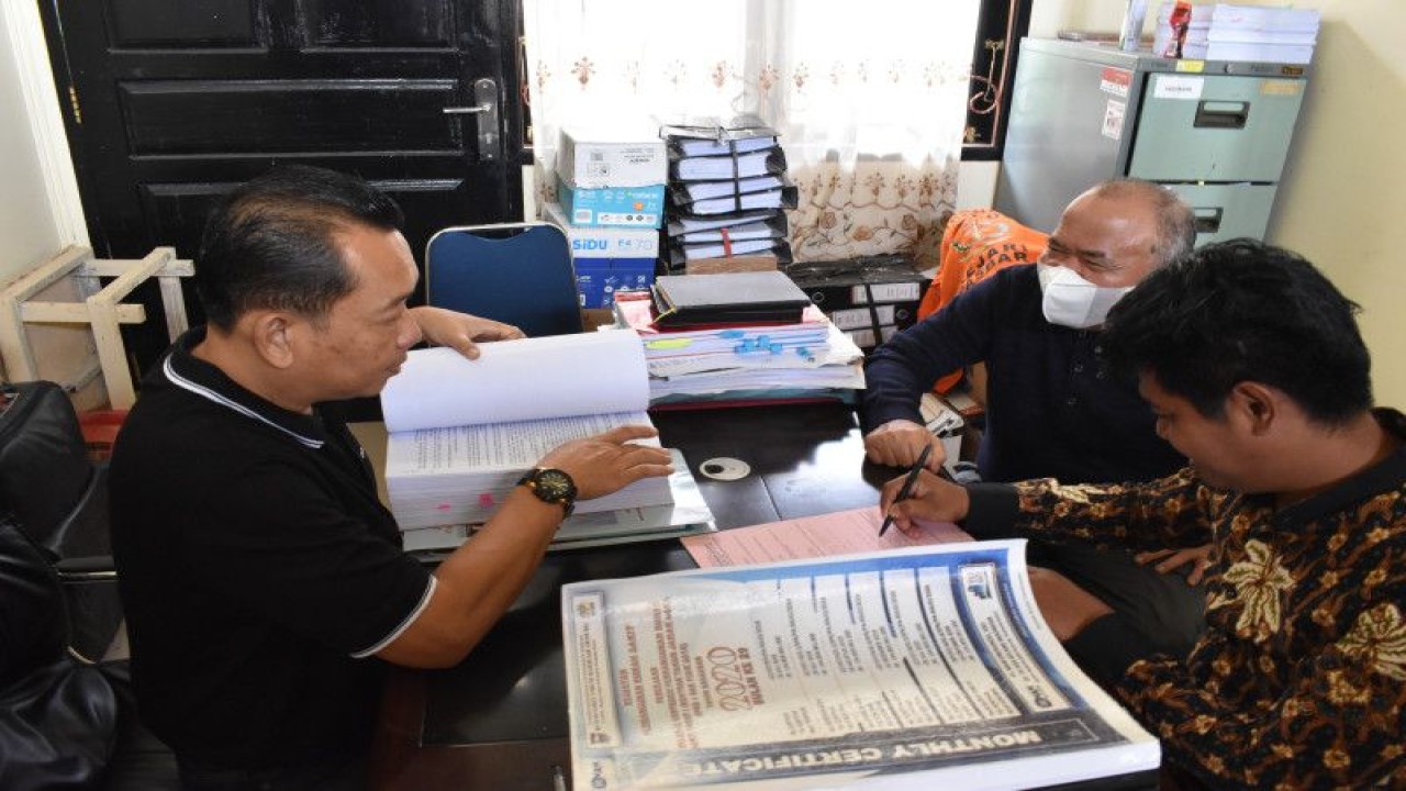 Penyidik Kejaksaan Negeri Pasaman Barat saat memeriksa berkas dari satu orang tersangka AM (dua kanan/masker) usai penyerahan tersangka dan barang bukti perkara korupsi pembangunan RSUD tahun anggaran 2018-2020 ke Penuntut Umum, Jumat. (ANTARA/HO-AM)