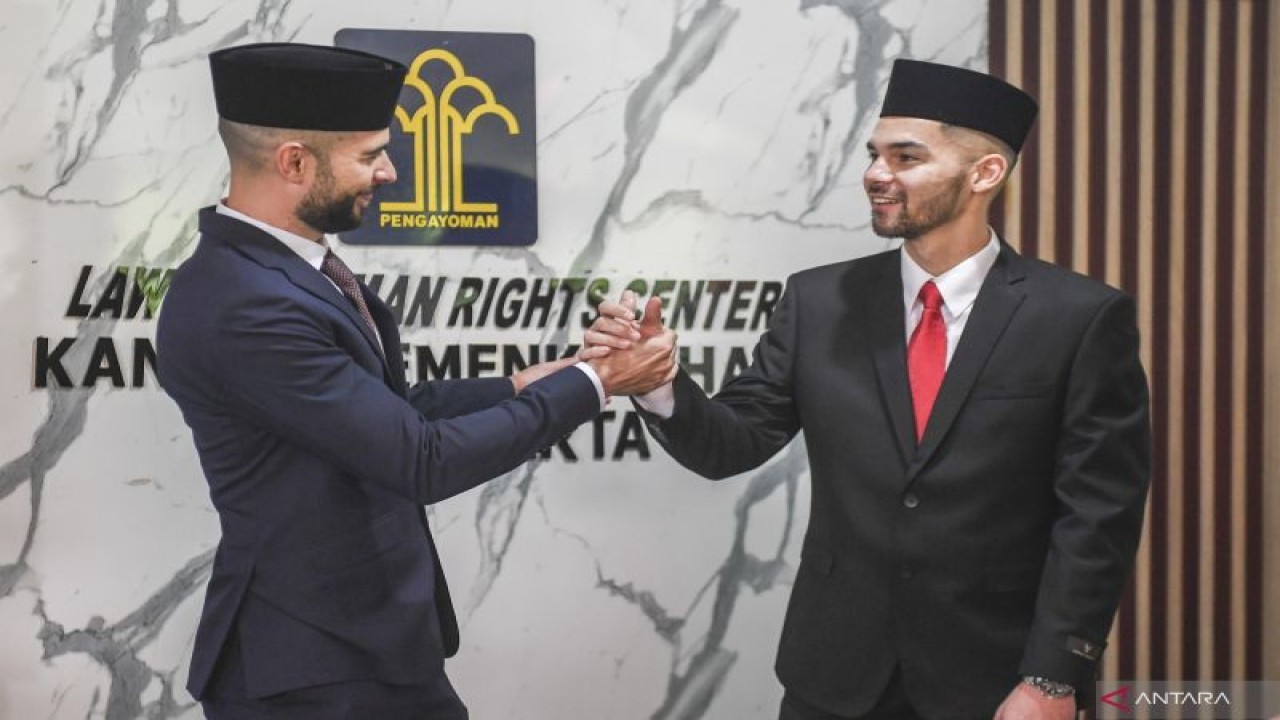 Pesepak bola Sandy Walsh (kanan) dan Jordi Amat (kiri) berjabat tangan usai membacakan Sumpah Janji Setia Pewarganegaraan di Kantor Wilayah Kemenkum HAM DKI Jakarta, Kamis (17/11/2022). ANTARA FOTO/Hafidz Mubarak A/foc.