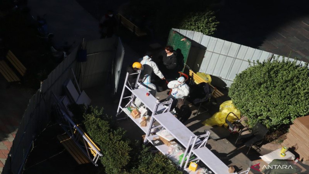 Petugas kesehatan berjaga di depan pintu masuk kompleks apartemen di Distrik Chaoyang, Beijing, China, yang ditutup pagar seng, Senin (21/11/2022), karena sedang diberlakukan karantina wilayah atau lockdown secara parsial. ANTARA/M. Irfan Ilmie
