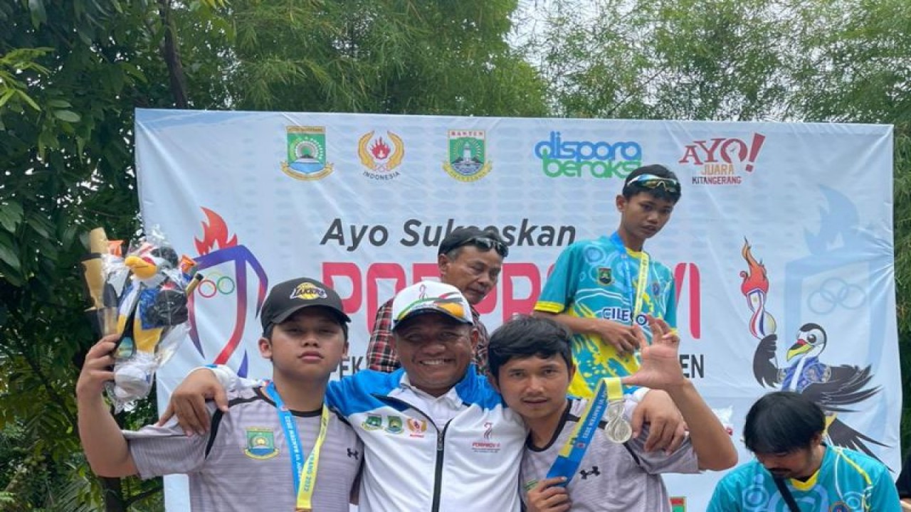 Ketua Umum Persatuan Olahraga Sepatu Roda Seluruh Indonesia (PORSEROSI) Kota Tangerang, Ujang Hendra (tengah) bersama dua atlet skateboard usai penyerahan medali.