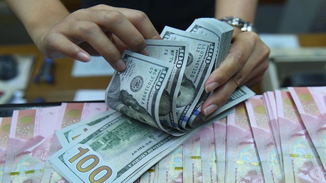 Ilustrasi: Pekerja menghitung uang dolar Amerika Serikat dan rupiah di sebuah tempat penukaran uang di Jakarta. ANTARA FOTO/Akbar Nugroho Gumay/wsj/pri.