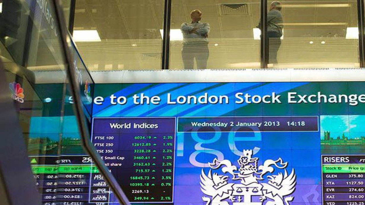 Pekerja terlihat berbincang di atas papan elektronik pergerakan saham di London Stock Exchange, Inggris. REUTERS/Paul Hackett/aa.