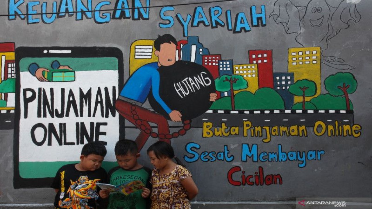Sejumlah anak bermain di dekat mural mengenai pinjaman online di kawasan Tempurejo, Surabaya, Jawa Timur. (ANTARA FOTO/Didik Suhartono/foc)