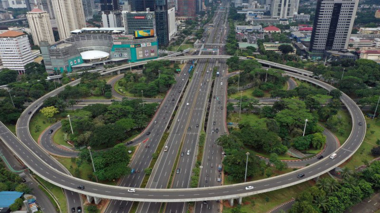 Foto aerial kendaraan melintas di Simpang Susun Semanggi, Jakarta, Senin (23/3/2020). Sejumlah ruas jalan utama ibu kota lebih lengang dibandingkan hari biasa karena sebagian perusahaan telah menerapkan bekerja dari rumah guna menekan penyebaran virus corona atau COVID-19. ANTARA FOTO/Indrianto Eko Suwarso/foc.