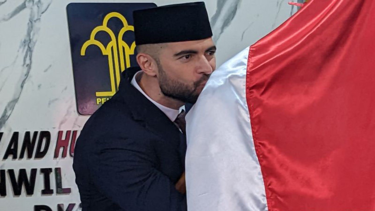 Pesepak bola Spanyol, Jordi Amat, mencium bendera Merah Putih di Kantor Wilayah Kementerian Hukum dan HAM DKI Jakarta, Jakarta, Kamis (17/11/2022), setelah dirinya resmi menjadi warga negara Indonesia. (ANTARA/Michael Siahaan)