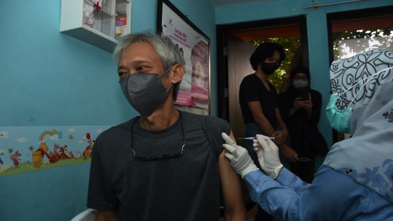 Petugas kesehatan menyuntikkan vaksin COVID-19 dosis keempat atau dosis penguat kedua kepada warga lansia dalam pelayanan vaksinasi di RPTRA Asoka, Jati Padang, Jakarta, Minggu (27/11/2022). (ANTARA FOTO/Indrianto Eko Suwarso)