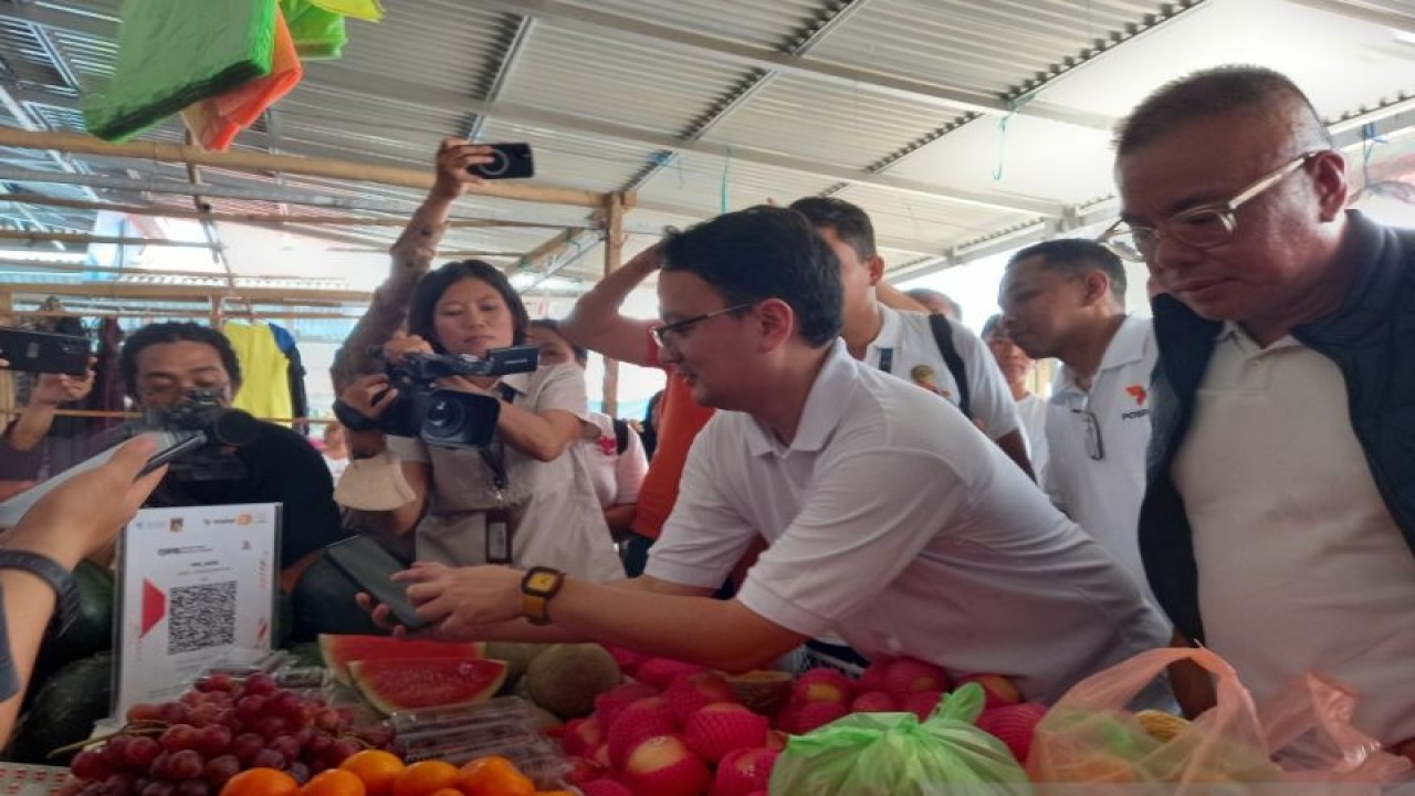 Wakil Menteri Perdagangan (Wamendag) Jerry Sambuaga bersama Staf Khusus Mendag Bara Hasibuan melakukan pembayaran menggunakan Pospay di Pasar Rakyat Sonder, Minahasa, Sulut, Jumat (11/11/2022). ANTARA/Nancy L Tigauw