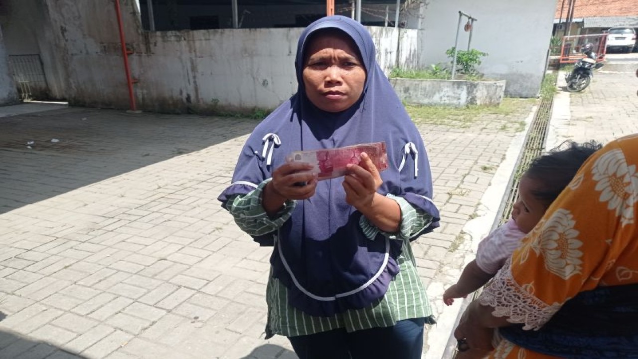 Seorang warga menunjukkan bantuan dana yang dia peroleh dari pemerintah di Kabupaten Lebak, Provinsi Banten. (ANTARA/Mansur)