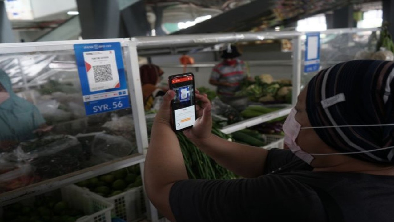 Warga melakukan transaksi menggunakan metode bayar scan QRIS dengan aplikasi DOKU e-Wallet di Pasar Tradisional Prawirotaman, Yogyakarta, Minggu (5/9/2021). ANTARA FOTO/Andreas Fitri Atmoko/aww.