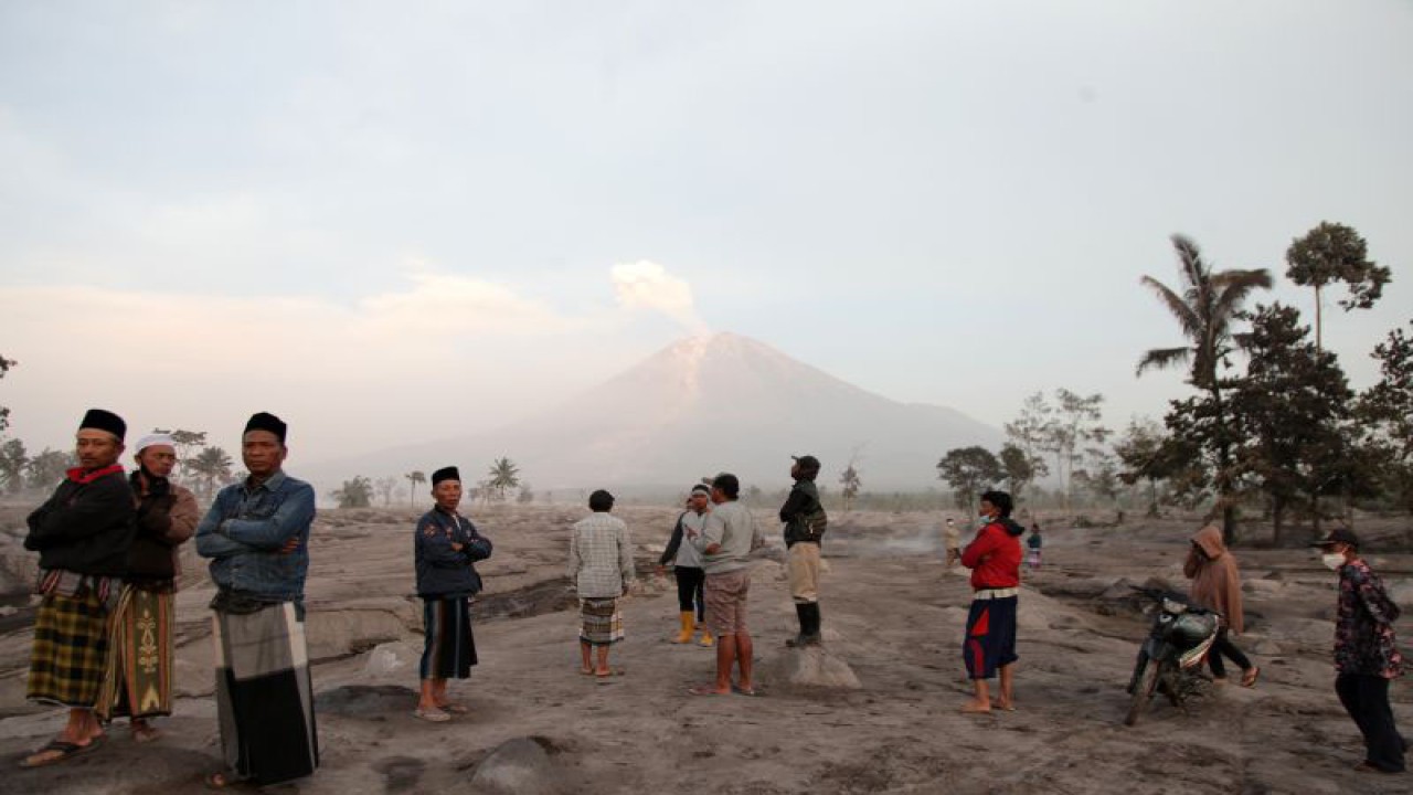 Warga melihat Gunung Semeru yang mengeluarkan material vulkanis dari Desa Sumberwuluh,Lumajang, Jawa Timur, Senin (5/12/2022). . ANTARA FOTO/Umarul Faruq/nym.