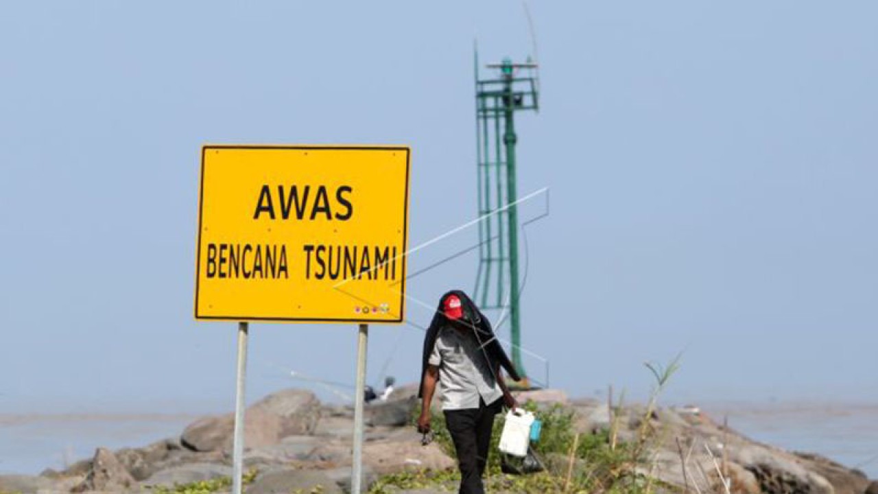 Arsip Foto - Warga berjalan di dekat rambu peringatan bencana tsunami di pantai wisata Kampung Jawa, Banda Aceh, Aceh, Selasa (8/1/2019). (ANTARA FOTO/Irwansyah Putra)