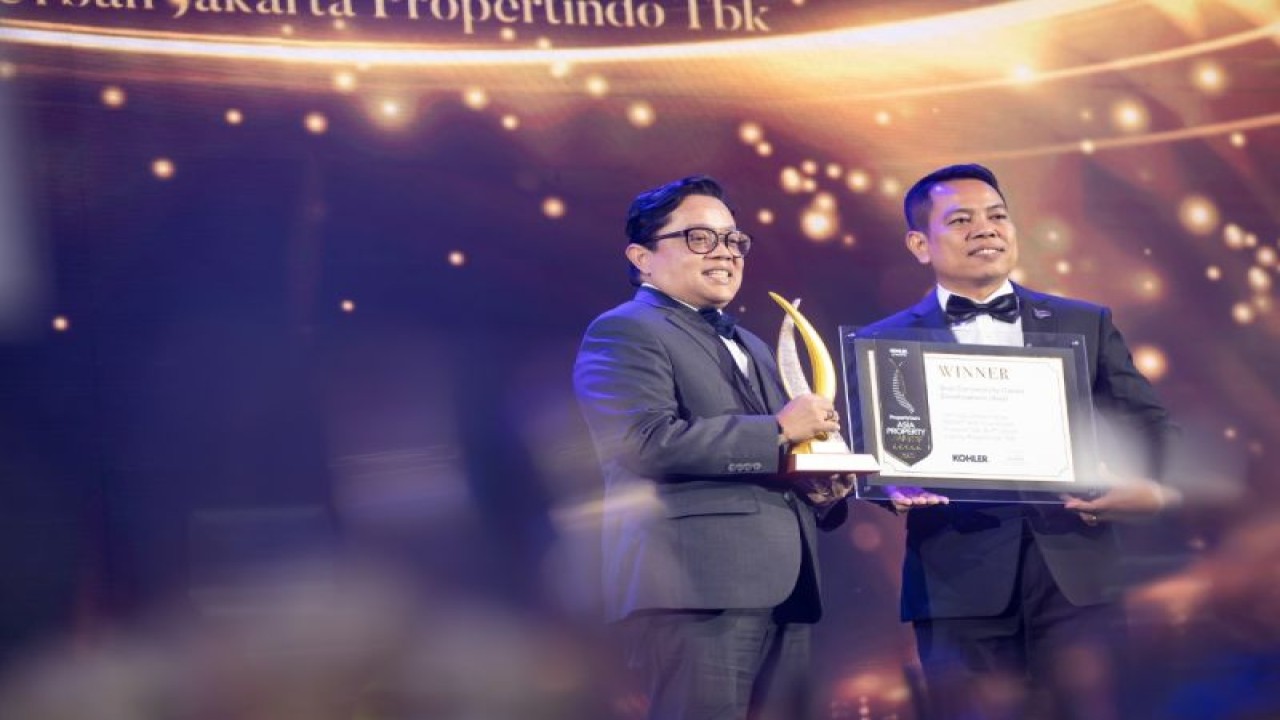 Direktur Utama PT Adhi Commuter Properti Tbk. (ADCP) Rizkan Firman (kiri) menerima trophi penghargaan terbaik dalam ajang PropertyGuru Asia Property Awards atau Anugerah Properti Asia PropertyGuru di Bangkok, Thailand, Jumat (9/12/2022). (Antara/HO/ADCP)