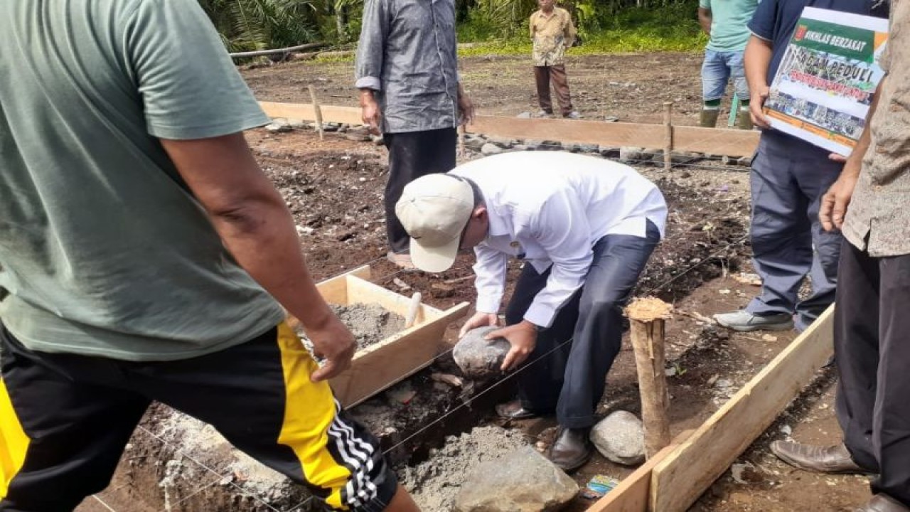 Ketua Baznas Agam Isman Imran sedang meletakkan batu pertama rumah di Cacang Tinggi, Nagari Tiku Utara, Kecamatan Tanjungmutiara, Rabu (14/12). (Antara/HO-Dok UPZ Nagari Tiku Utara)