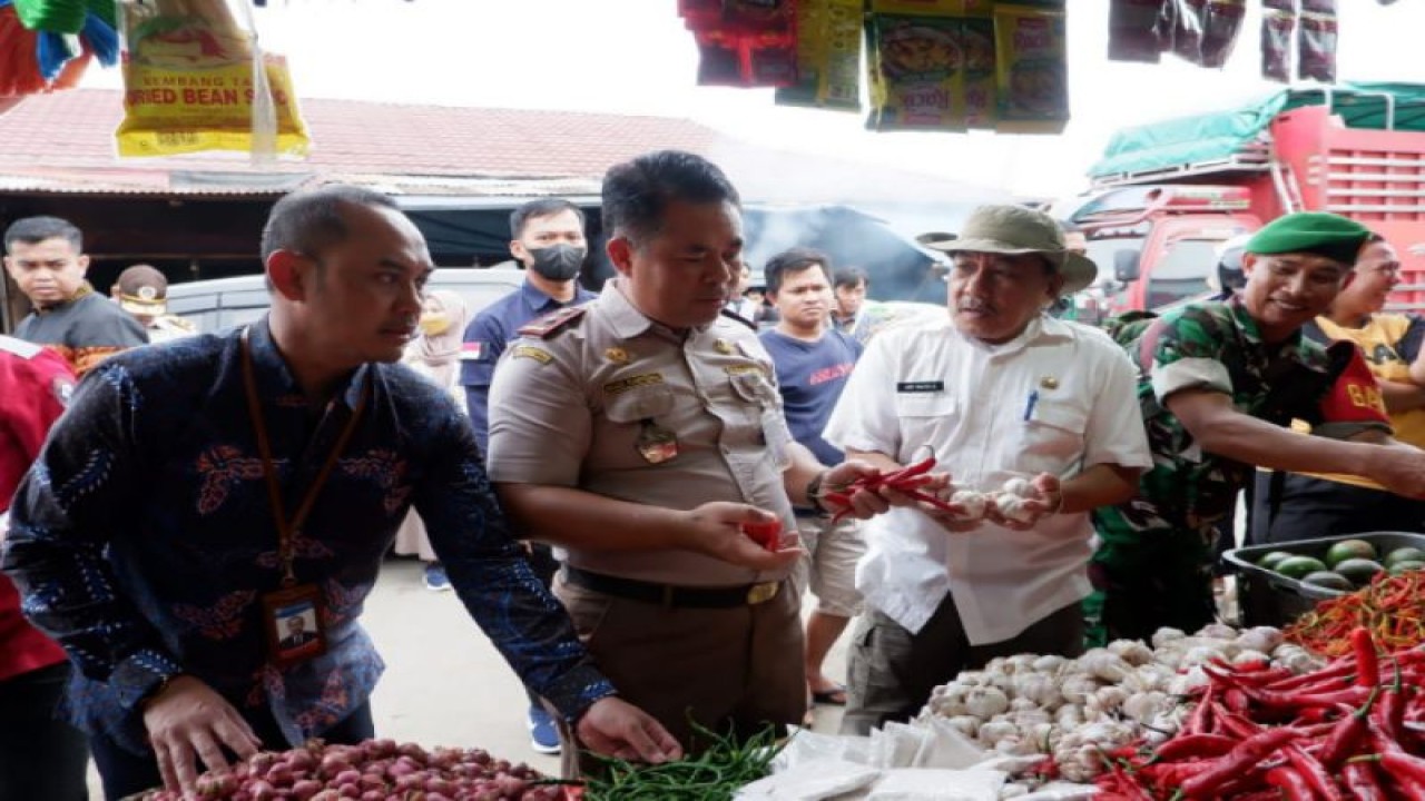 Kepala Karantina Pertanian Mamuju Agus Karyono (tengah) saat melakukan pengecekan stok dan harga bahan kebutuhan pokok di pasar tradisional di Mamuju, Jumat (30/12). (ANTARA/HO/Humas Karantina Pertanian Mamuju)