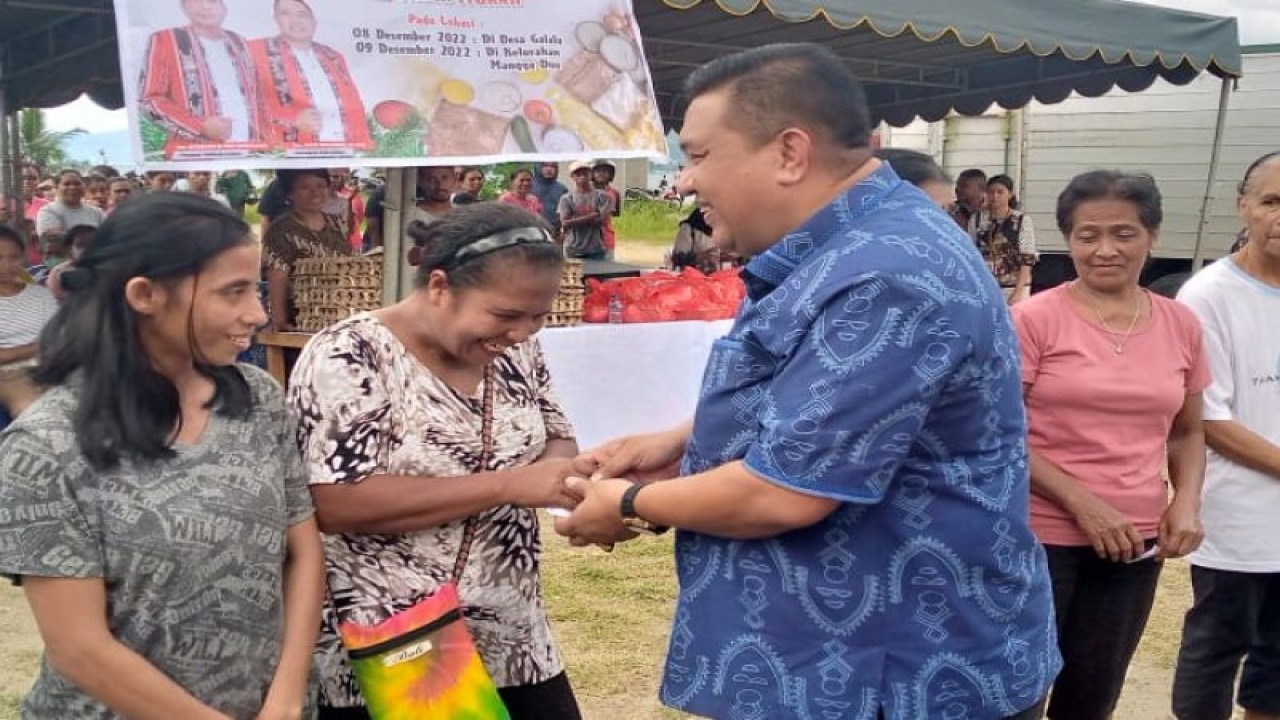 Sekretaris Kota Ambon Agus Ririmasse membagikan kupon pasar murah menyambut Natal kepada warga di Desa Galala kota Ambon, Kamis (8/12). ANTARA/Penina F Mayaut.