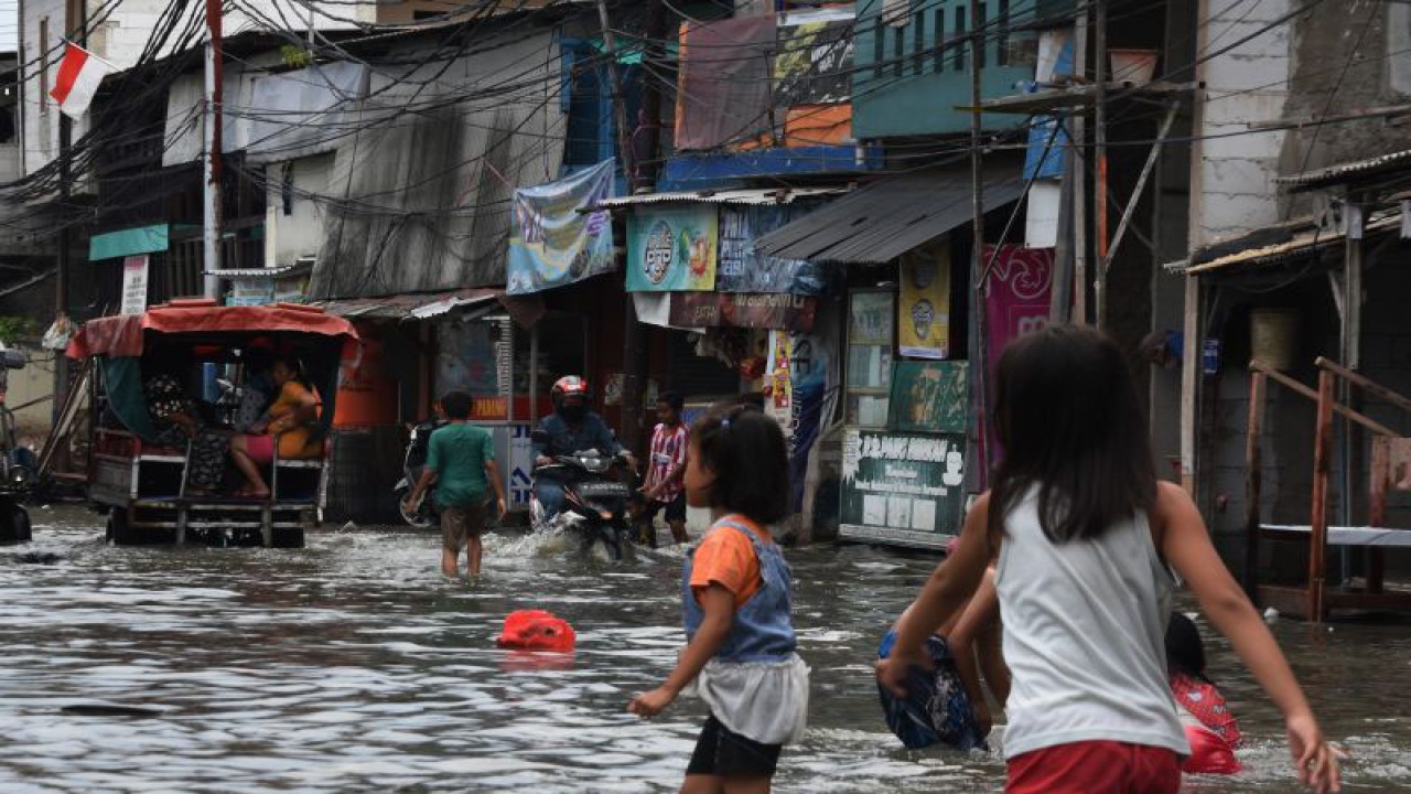 Sejumlah anak bermain saat banjir rob melanda kawasan pemukiman Muara Angke, Penjaringan, Jakarta Utara. Jumat (25/11/2022). Badan Meteorologi Klimatologi dan Geofisika (BMKG) merilis sembilan wilayah pesisir DKI Jakarta berpotensi terkena banjir rob yang diperkirakan terjadi pada 22-28 November 2022, diantaranya kawasan Kamal Muara, Kapuk Muara, Penjaringan, Pluit, Ancol, Kamal, Marunda, Cilincing, dan Kalibaru. ANTARA FOTO/Indrianto Eko Suwarso/foc.