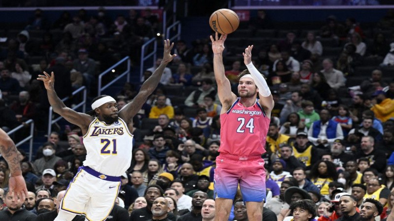 Pebasket Los Angeles Lakers Patrick Beverley (kiri) berupaya menghalau tembakan pebasket Washington Wizards Corey Kispert saat kuarter pertama pertandingan NBA kedua tim di Capital One Arena Washington, DC. Minggu (4/12/2022) (Getty Images via AFP/GREG FIUME)