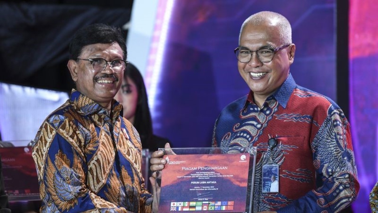 Menteri Komunikasi dan Informatika Johnny G. Plate (kiri) memberikan piagam penghargaan Apresiasi Tim Komunikasi Publik dan Media Presidensi G20 kepada Direktur Pemberitaan Perum LKBN Antara Akhmad Munir (kanan) di Jakarta, Selasa (20/12/2022). ANTARA FOTO/M Risyal Hidayat/pras.