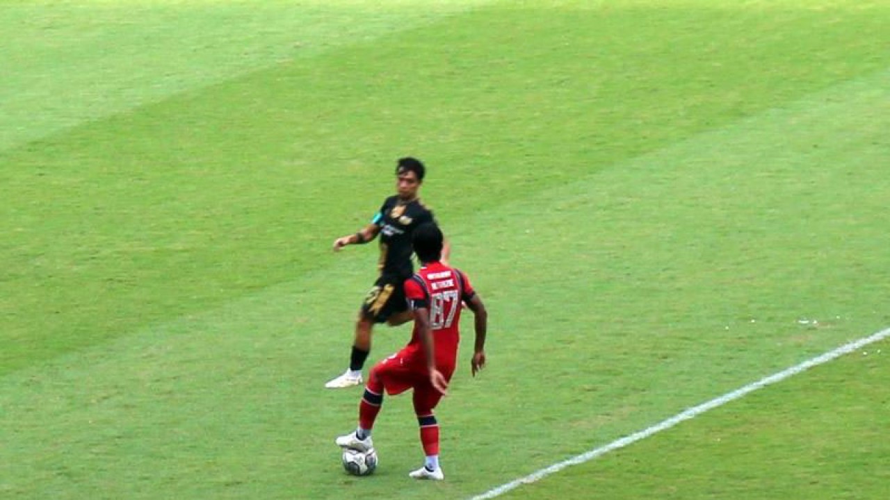 Pemian nomor punggung 87 Arema FC Johan Ahmat Farizi (kostum merah merah) saat membawa bola dihadang pemain nomor 15 Dewa United , Rangga Muslim,(kostum hitam hitam) dalam pertandingan Liga 1 2022 di Stadion Manahan Solo, Rabu (7/12/2022). ANTARA/Bambang Dwi Marwoto.