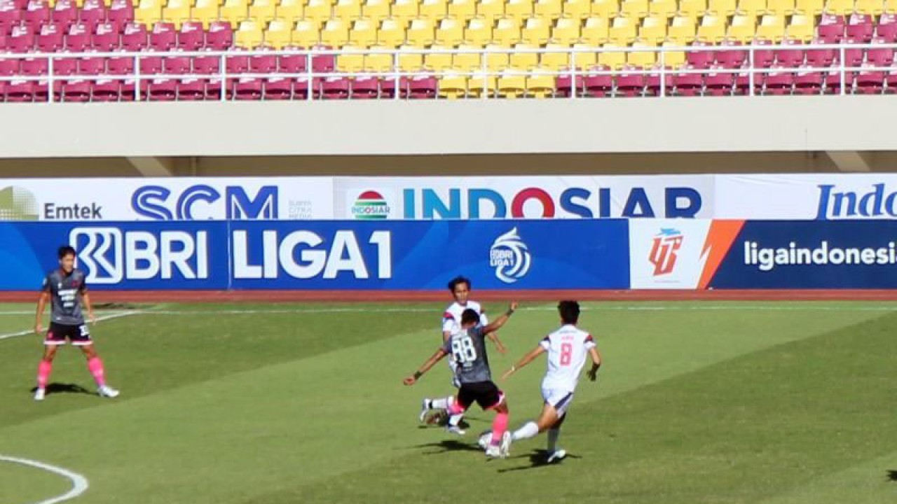 Pemain nomor punggung 88 Persita Fareza Sudin (kostim abu hitam) saat menendang bola dengan dijaga ketat pemain nomor punggung 8 Arema, Renshi Yamaguchi (kostum putih putih) dalam pertandingan Liga 1 Musim 2022 di Stadion Manahan Solo, Sabtu (17/12/2022). ANTARA/Bambang Dwi Marwoto.